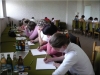 Uczestnicy spotkania siedzący przy oknach zajęci rozwiązywaniem testów