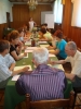 Uczestnicy projektu Aktywni, zintegrowani, silniejsi siedzą przy stole biorąc udział w treningu interpersonalnym